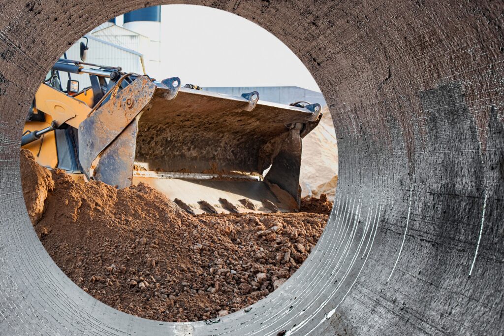 Excavator loader works with a bucket for transporting sand to and at site.