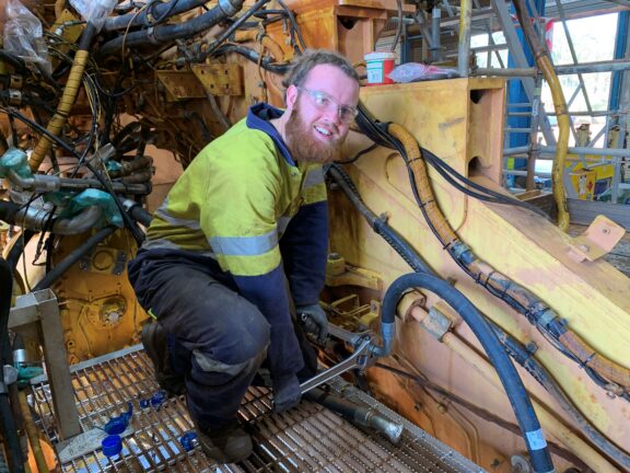 Alcoa fitter Riley Jenkinson replaces a hose on a Cat 993 loader.