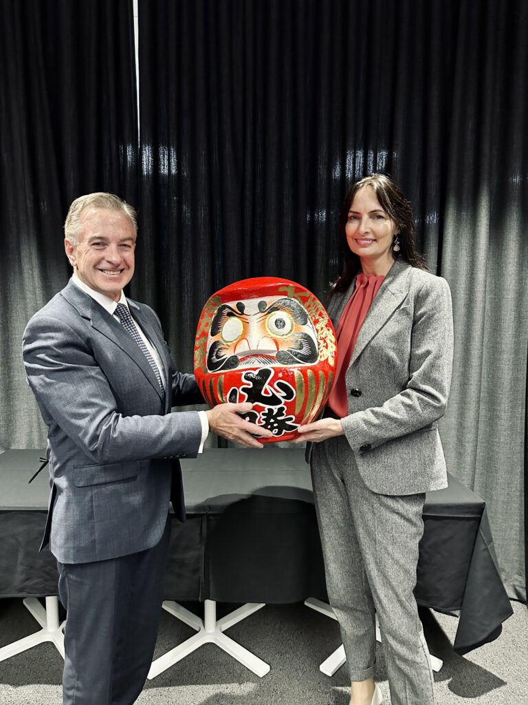 (Image source: BHP) (L-R) Toyota Australia president and chief executive Matthew Callachor and BHP president for Australia Geraldine Slattery. The object they are holding is a Daruma doll, which was handed from Toyota to BHP as part of a Japanese custom symbolising partnership. One eye is painted on at the beginning of the partnership, and the second eye is painted on when the goals of the partnership are achieved.