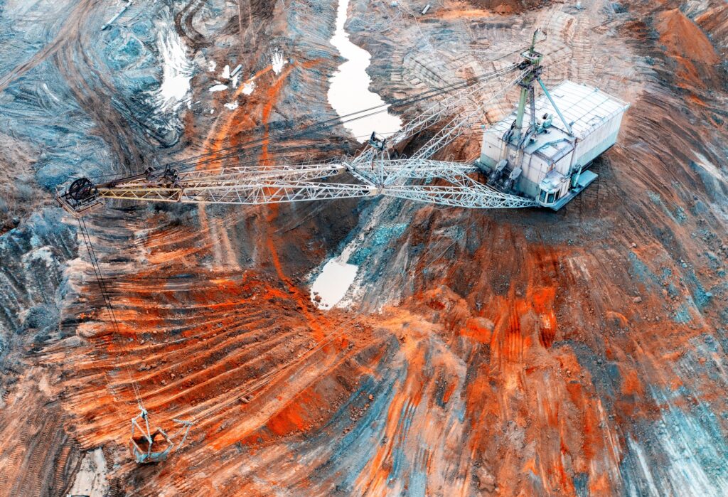 A large excavator working in a quarry for the extraction of rare metals.
