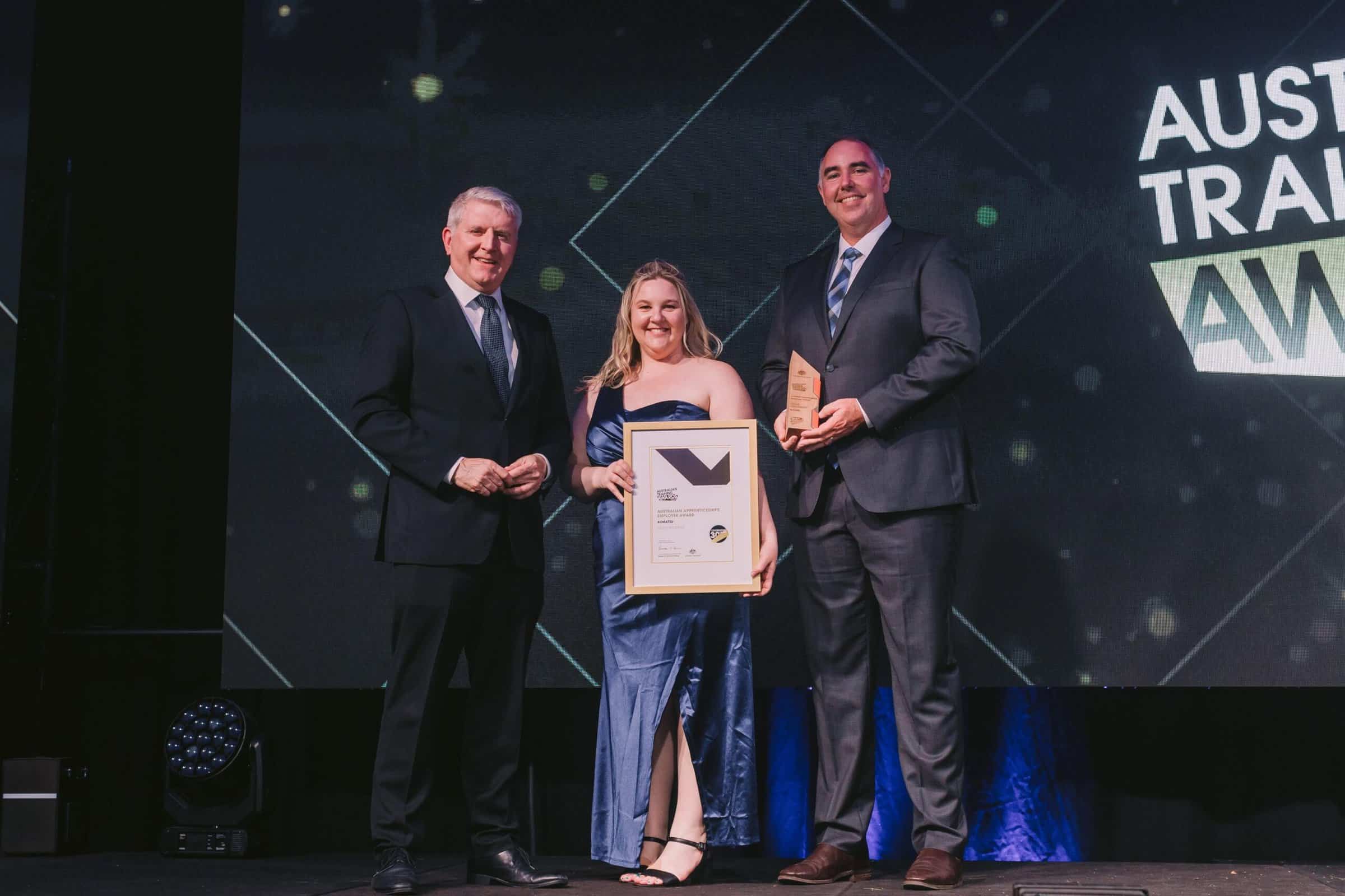 Komatsu national RTO & technical capability manager Matthew Tosolini and Komatsu technical capability coordinator Kirstyn Clarke accepting their gold award for Australian Apprenticeships Employer.