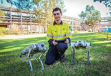Alcoa introducing paws-tively safer mining operations (Image source: Alcoa) Alcoa automation and robotics engineer Remi Hart with two robotic dog prototypes being trialled across a range of operational areas.