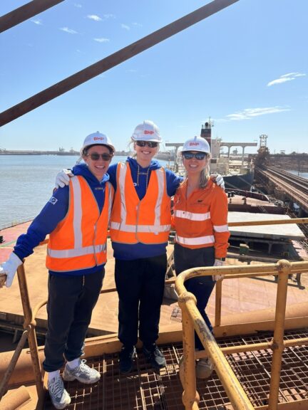 (Image source: BHP) AFLW West Coast Eagles stars Emma Swanson and Charlotte Thomas with BHP’s Stacey Turale on a ship loader at Port Hedland.