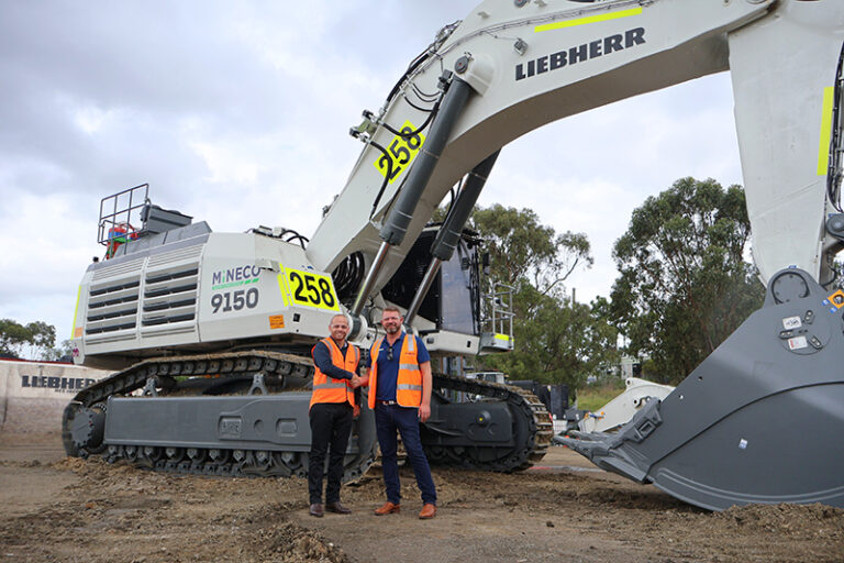 (Image source: Liebherr-Australia) Daniel Simone of Liebherr-Australia and Steven Arthur of Mineco with the first Liebherr machine to join Mineco’s fleet at Mount Arthur coal mine.